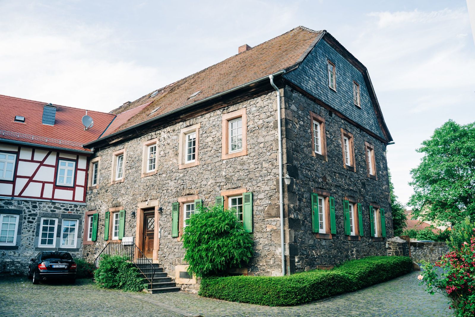 Das Bürogebäude in der Schlossgasse 6G in Lich, ein Haus aus Basaltstein mit grünen Fensterläden