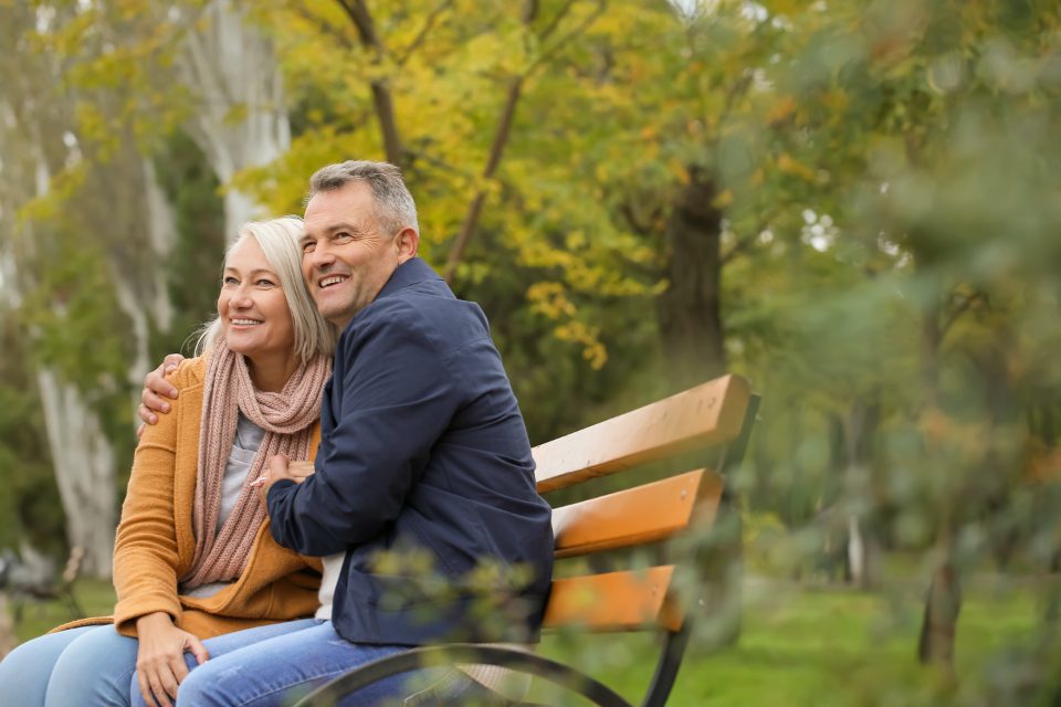 Älteres Paar auf einer Parkbank im Herbst